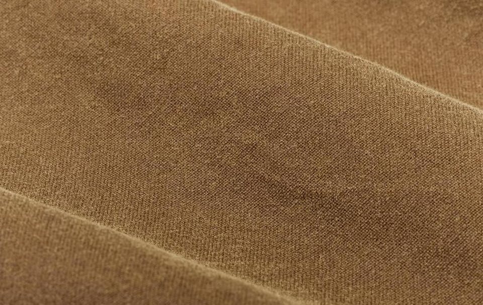 close up short of the texture of tan-colored tin cloth
